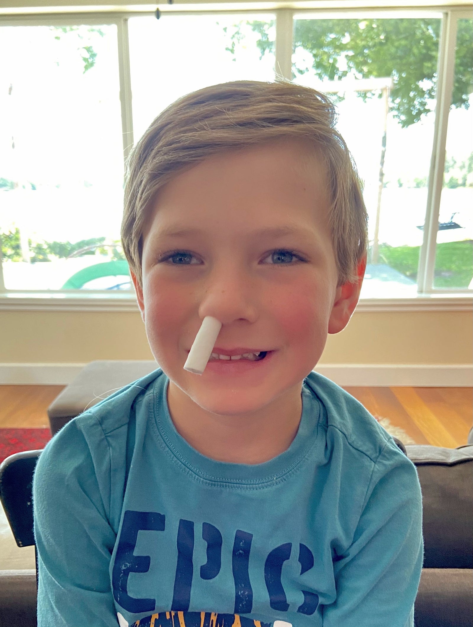 Kid with nosebleed plug in it's nose  